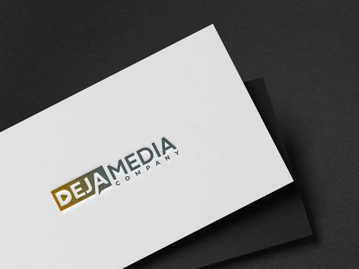 Deja Media business cards in gold foil, fanned on a dark surface.
